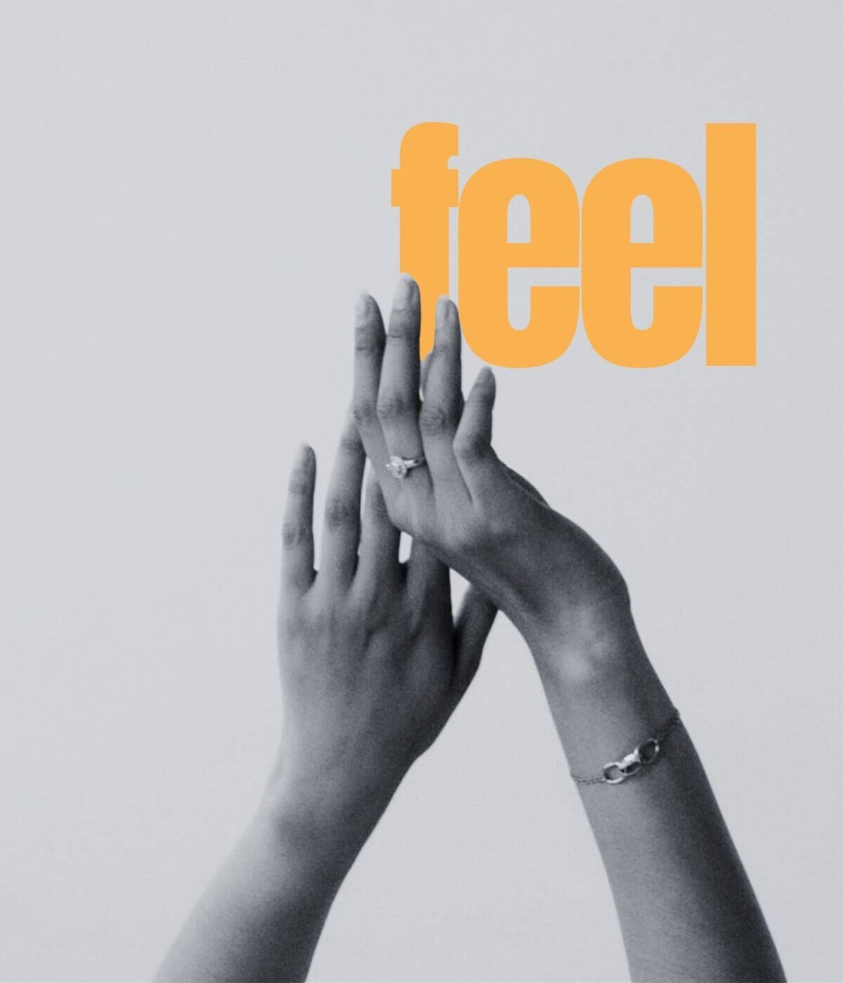 feel – zwei Hände, die sich im Licht berühren